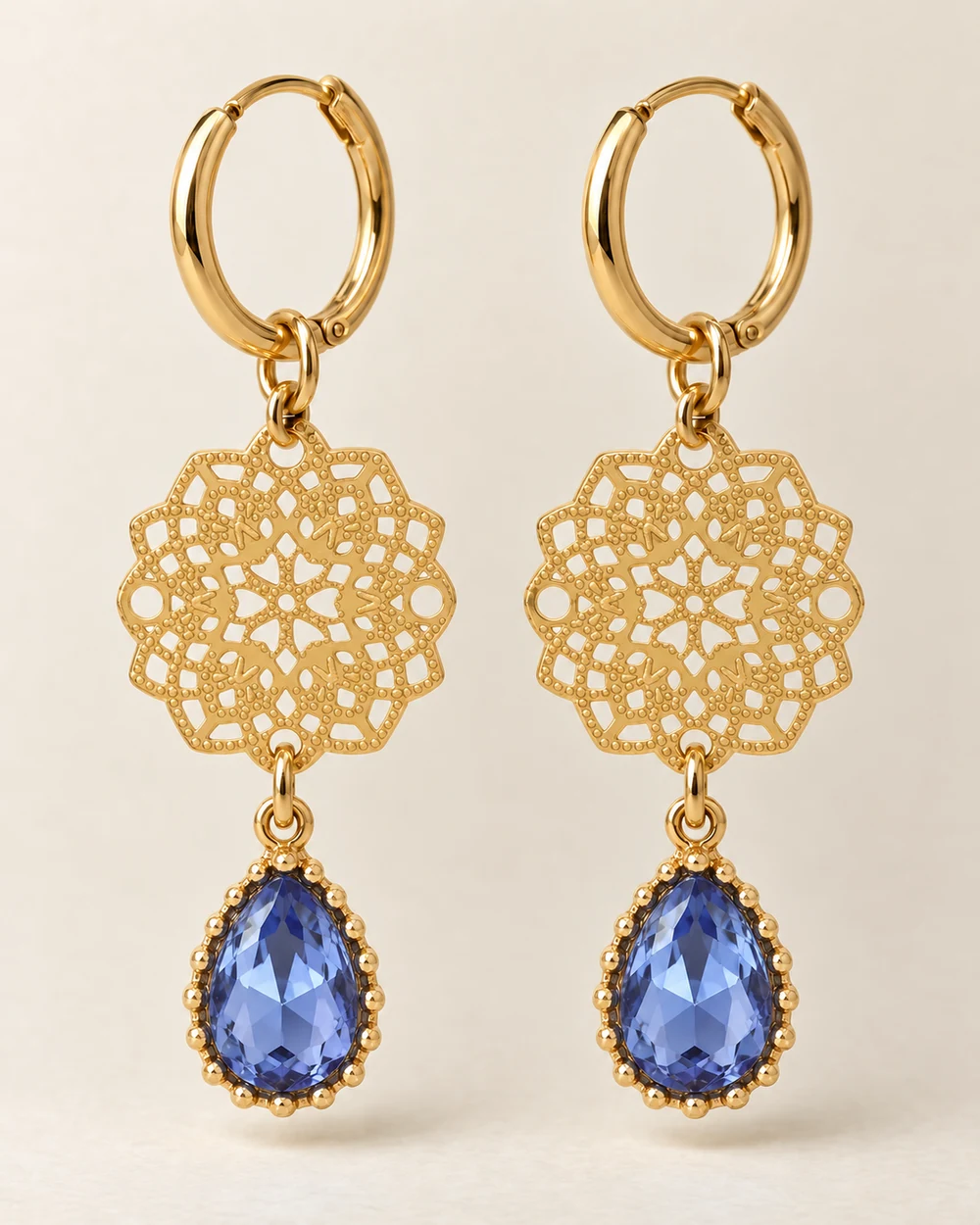 Azur — Rosace dorée à deux trous et goutte de verre bleu clair montée s’articulent en deux étages.