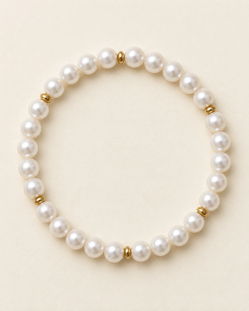 Coquille — Un bracelet souple : 28 perle nacrée synthétique 6 mm, 6 intercalaire doré 2 mm.