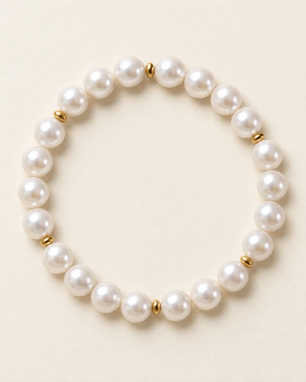 Graviers — Un bracelet souple : 22 perle nacrée synthétique 8 mm, 6 intercalaire doré 2 mm.