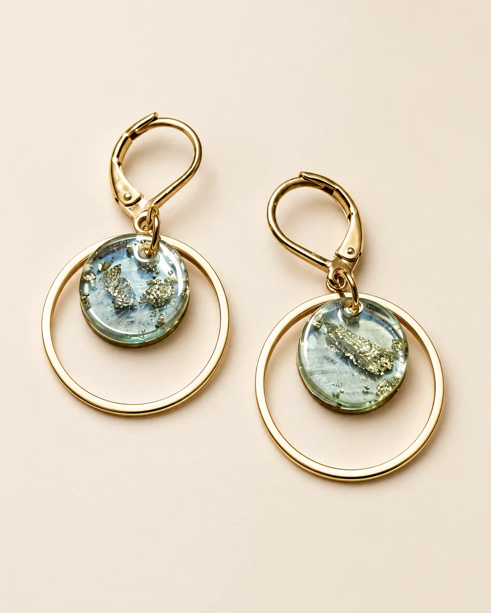 Marie-So — Dormeuses dorées, cercle fin et disque irisé vert-gris avec reflets dorés; la nature du disque n'est pas établie.