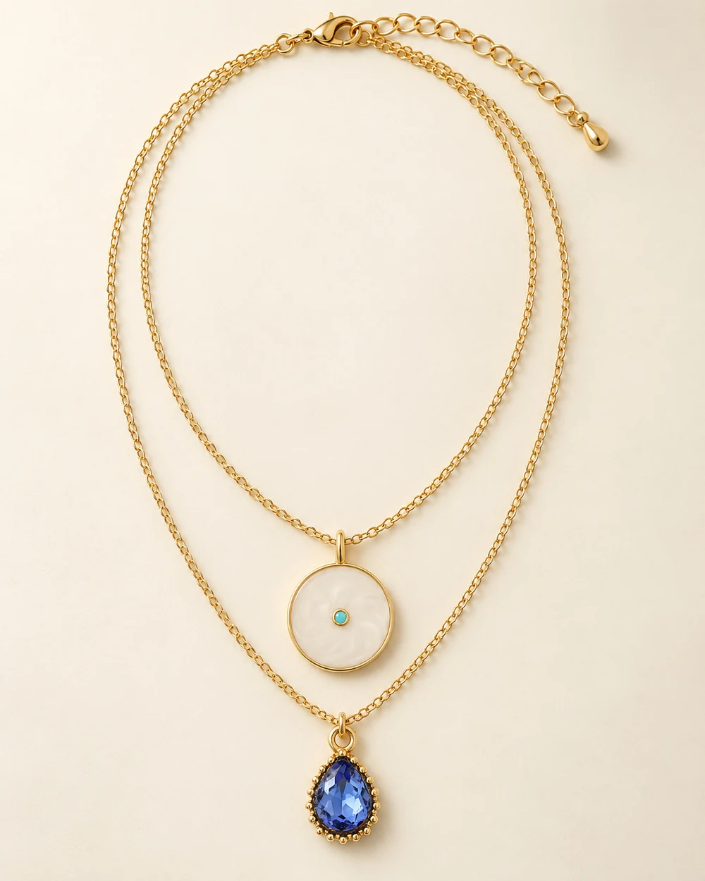 Opaline — Deux rangs fins, médaillon crème au-dessus de goutte de verre bleu clair montée.